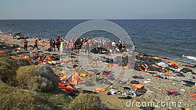 LESVOS, ГРЕЦИЯ - 5-ОЕ НОЯБРЯ 2015: Шлюпка разрешения беженцев резиновая около берега LESVOS, ГРЕЦИЯ - 5-ОЕ НОЯБРЯ 2015: Шлюпка разрешения беженцев резиновая около берега