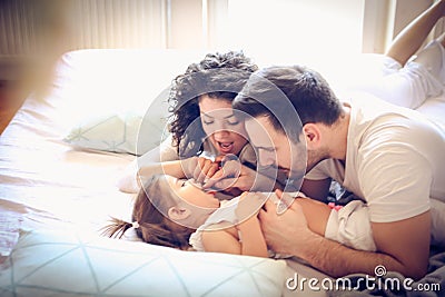 Let we count your teeth. Young parents with their little girl. Stock Photo