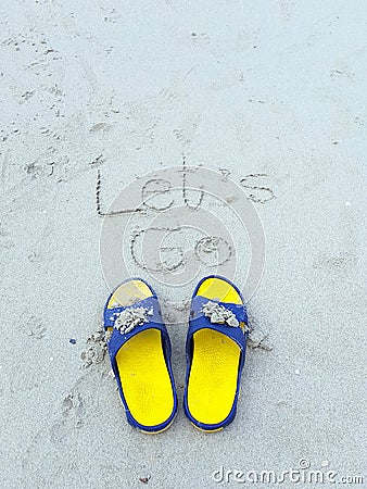 Let go word on the beach and yellow sandal Stock Photo