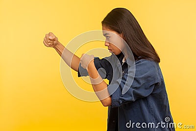 Let`s fight! Side view of confident courageous girl in denim shirt keeping fists clenched, boxing and punching to side Stock Photo