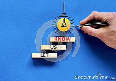 Let us know symbol. Concept words Let us know on wooden blocks on a beautiful blue table blue background. Yellow light bulb. Stock Photo