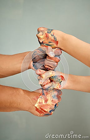 Lets bring some colour in here. a young couple standing with their fists stacked while painting. Stock Photo