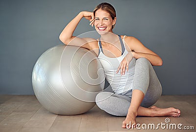 Lets play ball. a sporty young woman sitting next to her fitness ball. Stock Photo