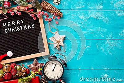 Letter board with words Merry Christmas, vintage clock and decorations on blue wooden table. Winter Christmas celebration concept Stock Photo