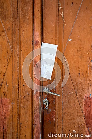 The letter in the envelope inserted in the door leaf. The lack of a mailbox. Mail delivery. Correspondence Stock Photo