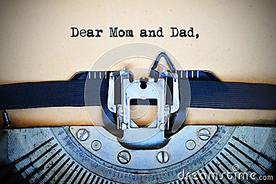 Letter for parents beginning with Dear mom and dad text typed by vintage typewriter machine Stock Photo