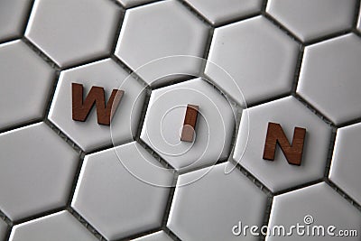 Letters forming the word Win on hexagon shaped tiles Stock Photo