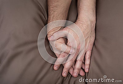 LGBT concept. Men holding hands on the bed Stock Photo