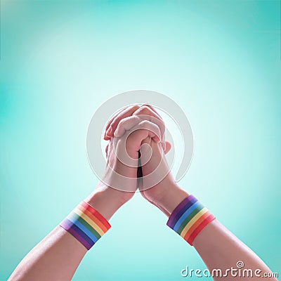 LGBT pride month with rainbow flag ribbon wristbands on LGBTQ people holding hands isolated with clipping path Stock Photo