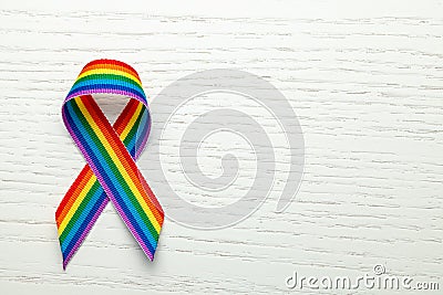 LGBT rainbow ribbon pride symbol. Stop homophobia. White wood background. Copy space for text. Stock Photo
