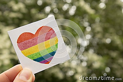 LGBT symbol. Hand holding watercolor rainbow heart. Stock Photo