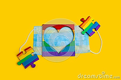 LGBT symbol puzzles and heart frame on a medical mask. Coronavirus quarantine, online festival and pride day 2020 Stock Photo