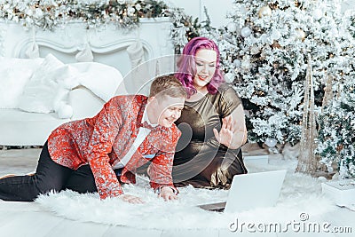 LGBTQ lesbian homosexual couple celebrating Christmas or New Year. Gay young lady female woman with butch partner calling friends Stock Photo