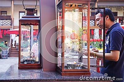 Lhong 1919, a man light the incense by fire Editorial Stock Photo