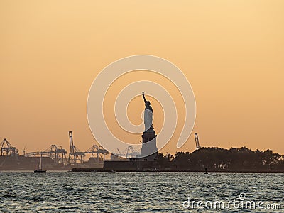 Liberty island, New York City - Statue of Liberty on Hudson river during cruise sunset at dusk Editorial Stock Photo