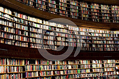 Library interior featuring a wall of bookshelves filled with various books. Stockholm Editorial Stock Photo