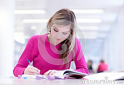 In the library - pretty female student Stock Photo