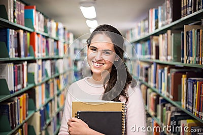 In the library - pretty female student with books working in a h Stock Photo