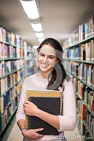 In the library - pretty female student with books working in a h Stock Photo