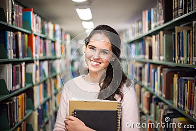 In the library - pretty female student with books working in a h Stock Photo