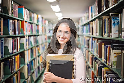 In the library - pretty female student with books working in a h Stock Photo