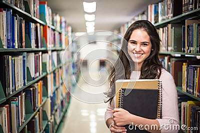 In the library - pretty female student with books working in a h Stock Photo