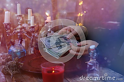 Librate with money, female hands of psychic doing witchcraft passes with dollars, esoteric Oracle performs ritual of removing Stock Photo