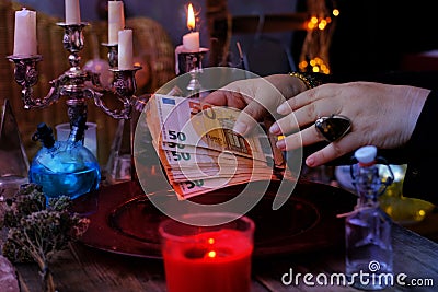 Librate with money, female hands of psychic doing witchcraft passes with euro banknotes, esoteric Oracle performs ritual of Stock Photo