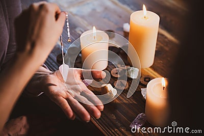Librate with an pendulum over the hand, healing or oracle foretelling Stock Photo