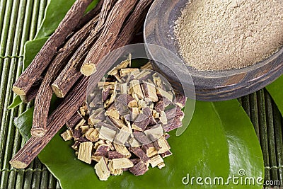 Licorice root in bowl on wooden background Stock Photo
