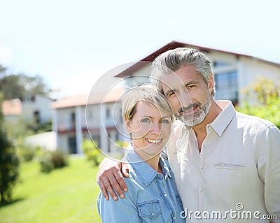 Liddle-aged couple standing on front of the house Stock Photo