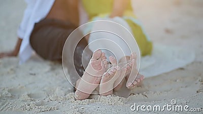 Liefdepaar die op het zand en hun naakte voeten liggen Liefdespel van voeten De straal van de zon bij zonsondergang glijdt in het stock videobeelden Liefdepaar die op het zand en hun naakte voeten liggen Liefdespel van voeten De straal van de zon bij zonsondergang glijdt in het stock videobeelden