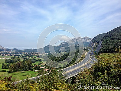 Liendo and highway curve surrounded by mountainous landscape Stock Photo