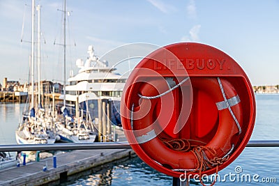 a life boy at a marina with out of focus yachts in the background Stock Photo