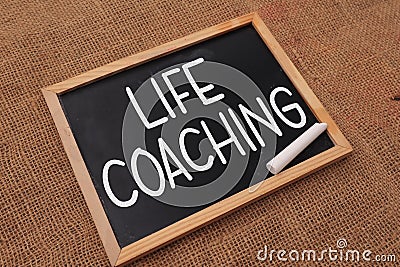 Life coaching, text words typography written on chalkboard against wooden background, life and business motivational inspirational Stock Photo