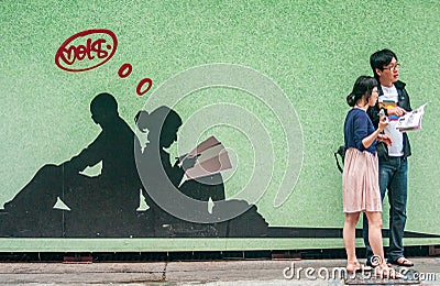 Life couple in front of wall painting, Hong Kong Island, China Editorial Stock Photo