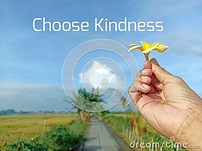 Life inspirational quote - Choose kindness. With person holding Bali frangipany flower against blue sky. Stock Photo