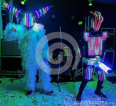 Life-size puppets in the form of robots on a stage. Funny amateur dance Editorial Stock Photo