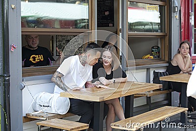 Life of street cafe. Man and woman sitting at a table at an outdoor menu, choosing food Editorial Stock Photo