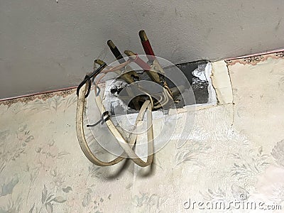 A life-threatening connection of wires protruding from the wall under electrical voltage. Connection of aluminum and copper wires Stock Photo