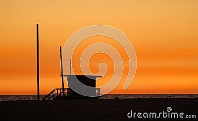 A lifeguard shack on a beach against a golden sunset Stock Photo