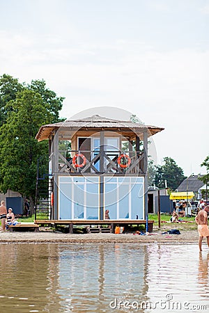 Lifeguard tower for rescue baywatch on beach. Wooden house on sea shore on cloudy sky background. Summer vacation and resort. Editorial Stock Photo