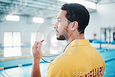 Lifeguard, whistle and swimming pool safety by man watching at indoor facility for training, swim and practice. Pool Stock Photo