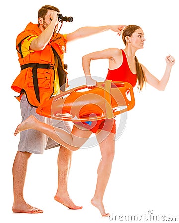 Lifeguards in life vest with rescue buoy running Stock Photo