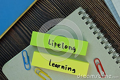 Lifelong learning write on sticky notes isolated on Wooden Table. Education concept Stock Photo