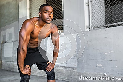 Lifestyle of african american athlete preparing for run, jogging, intense conviction, determination, serious stare, powerful eyes Stock Photo