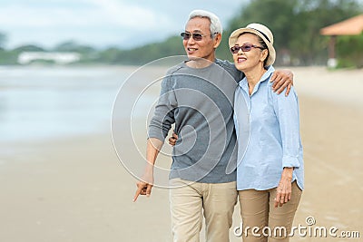 Lifestyle asian senior couple happy walking and relax on the beach. Tourism elderly family travel leisure and activity after reti Stock Photo