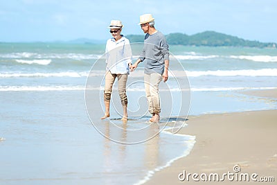 Lifestyle asian senior couple walking happy and relax on the beach. Stock Photo