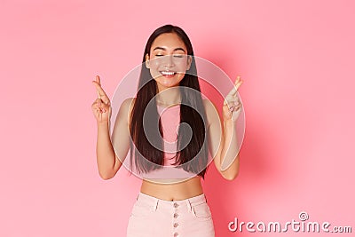 Lifestyle, beauty and women concept. Portrait of hopeful, happy asian girl in summer clothes making wish, cross fingers Stock Photo