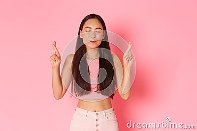Lifestyle, beauty and women concept. Portrait of hopeful, happy asian girl in summer clothes making wish, cross fingers Stock Photo